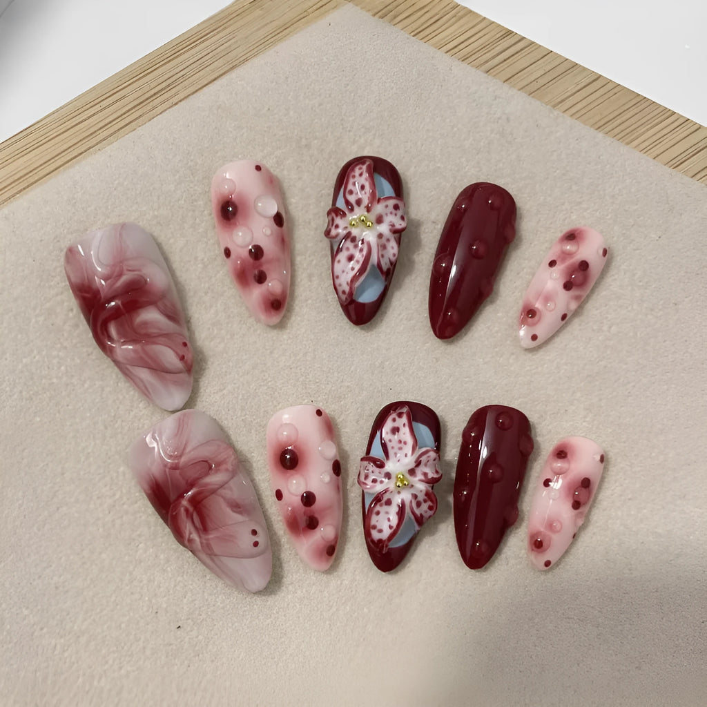 Almond shaped false nails with hand-painted 3D carved rose and tulip designs on a medium length nail.