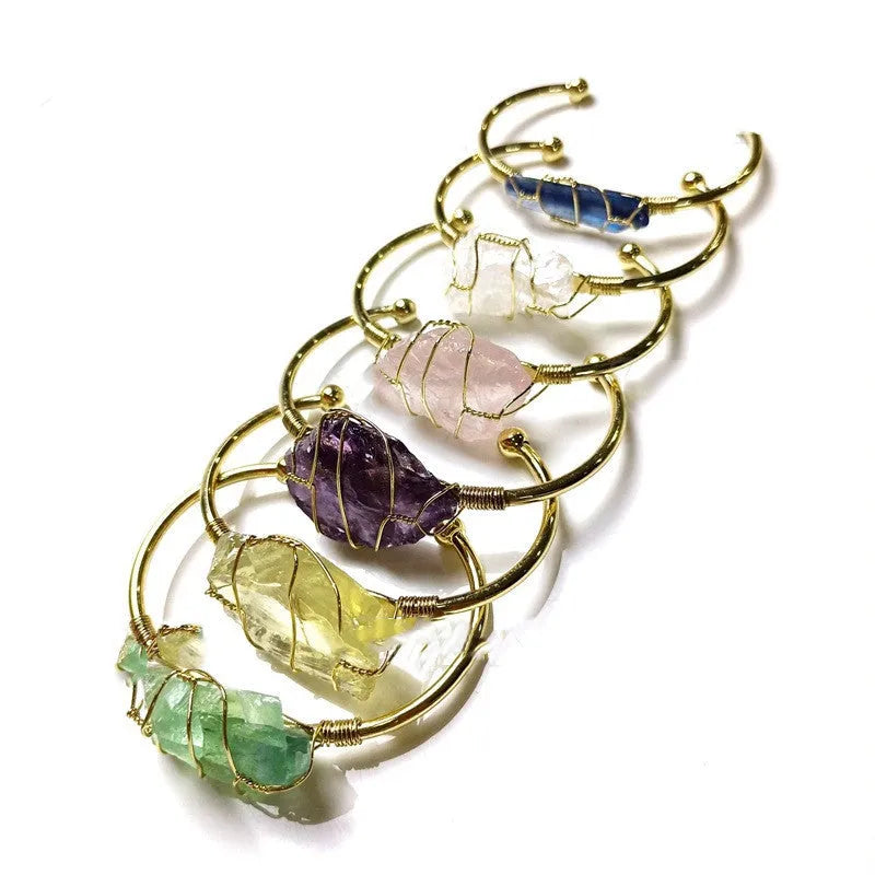 Unisex rough natural crystal bracelet with geometric gold metal winding on a wrist