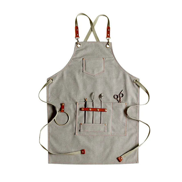 Canvas cross-back apron in camel colour on a mannequin, showing adjustable neck and waist ties