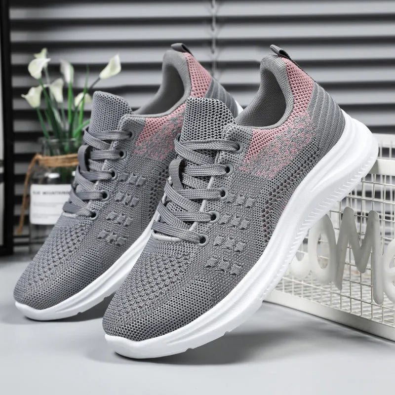Women's low-top black mesh sneakers with a round toe and white PVC sole on a plain background.