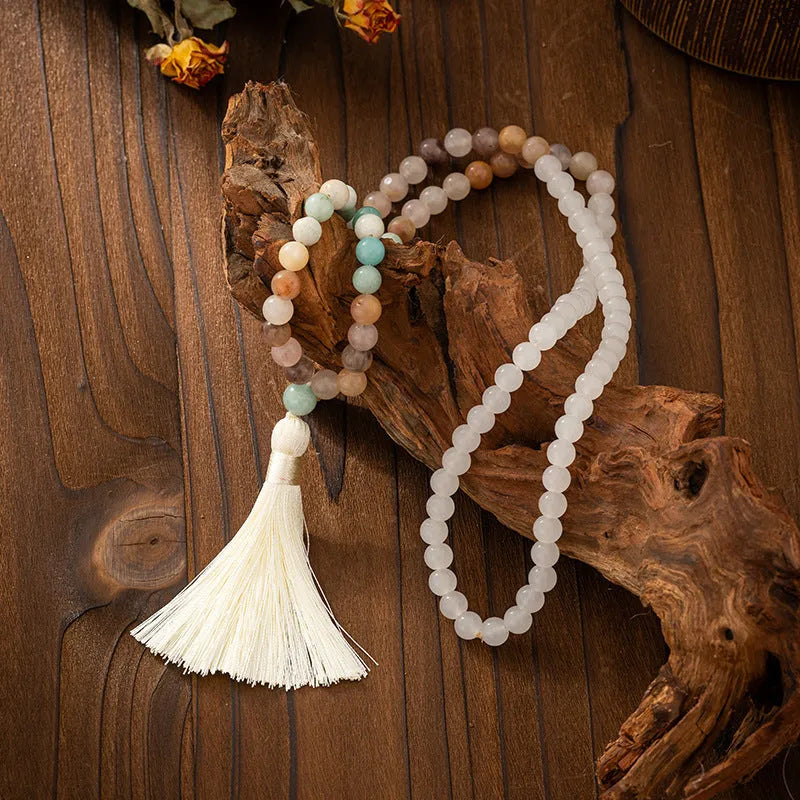 Bohemian-style long necklace chain with vintage tassel and matching bracelet on dark background