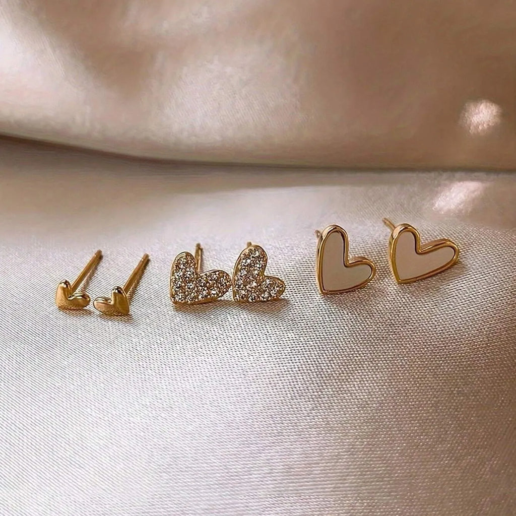 Three pairs of women's heart-shaped alloy earrings in gold, black, white and pink electroplated finishes
