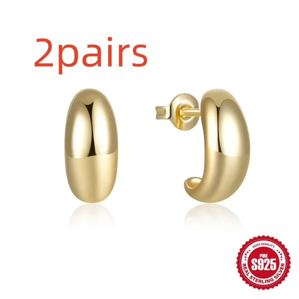 A pair of glossy C-shaped stud earrings in sterling silver, shown in gold and silver colour options.