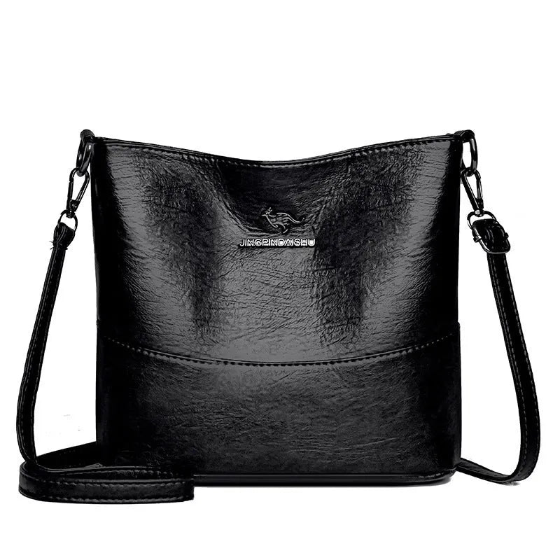 Women's solid colour soft leather bucket shoulder bag with sewing detail on strap, shown in ginger yellow.