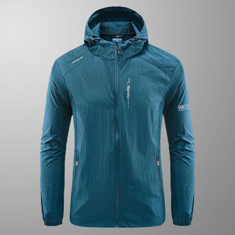 Man wearing a lightweight grey hooded nylon summer jacket outdoors.