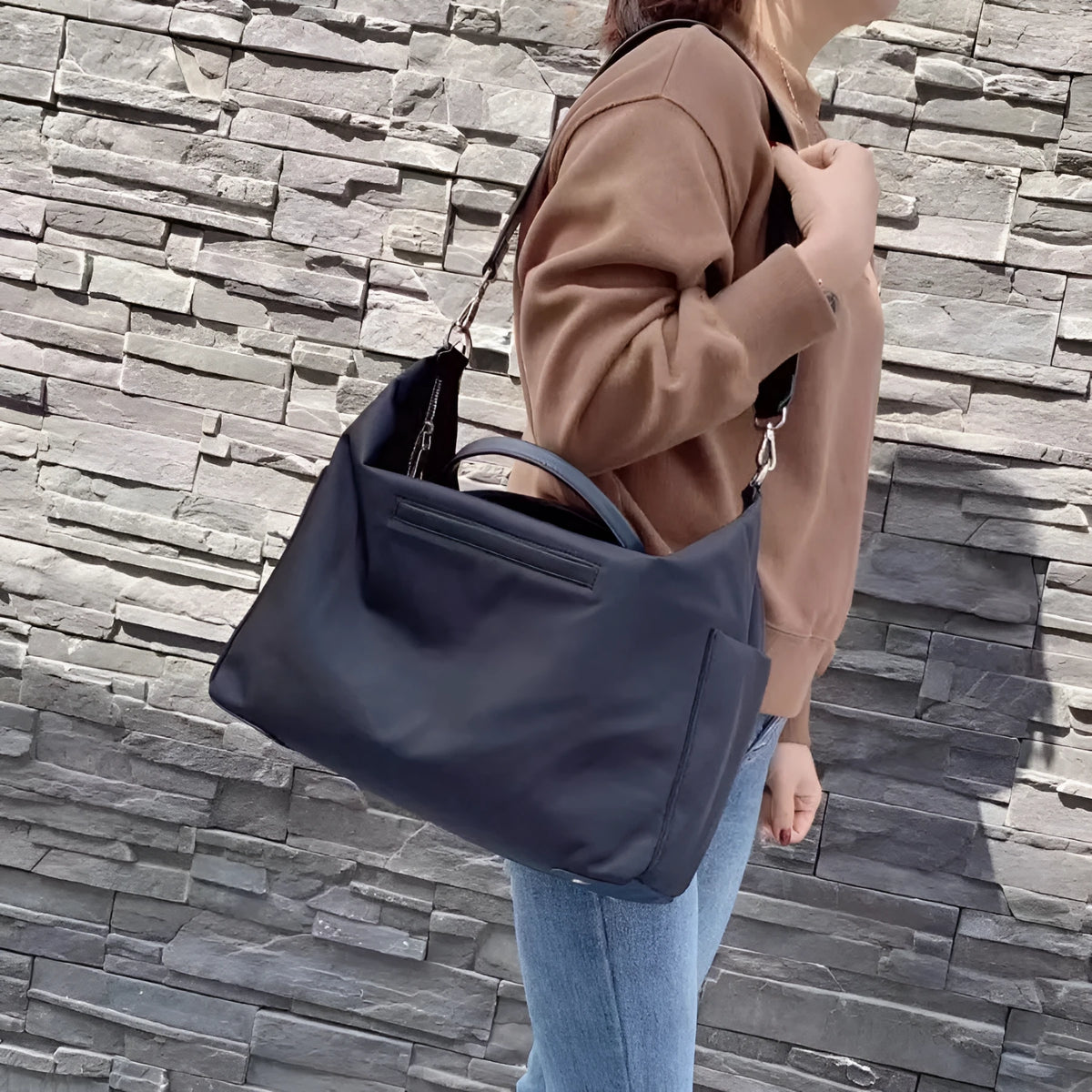 Black nylon waterproof shoulder bag with leather handles showing its large size