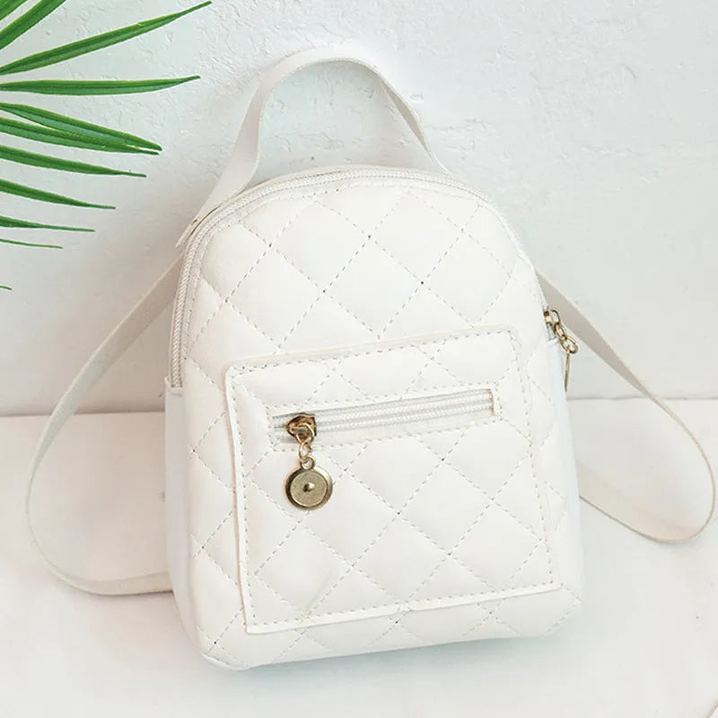 Hard-sided square pink backpack with embroidered detail, shown with soft carry handle and straps.