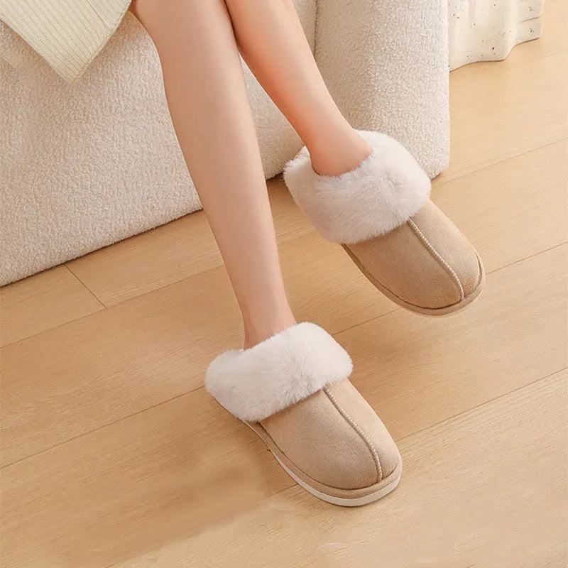 A pair of plush fur-lined indoor slippers with a round toe and a flat PVC sole.