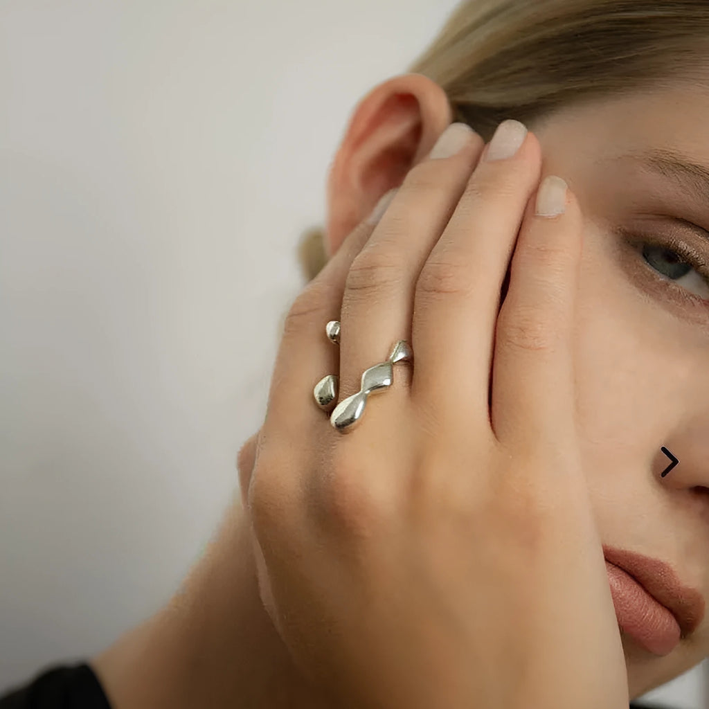 Brass adjustable fashion ring with spherical detail in gold or silver finish.