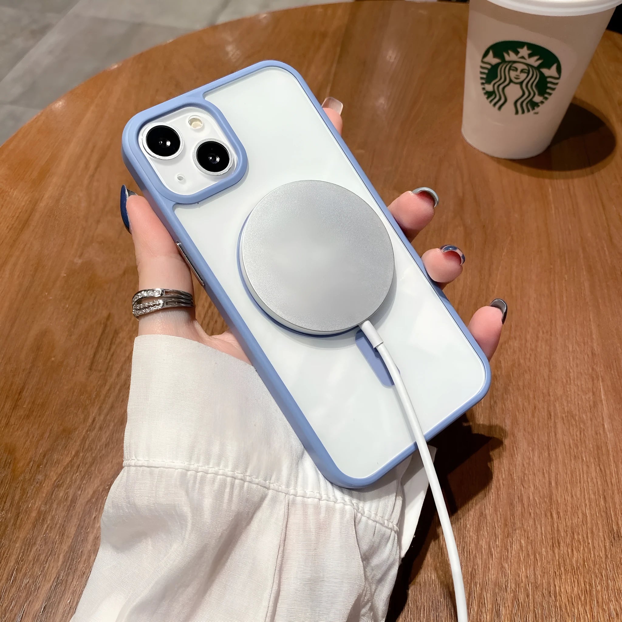 Clear acrylic MagSafe phone case for iPhone with magnetic ring visible through transparent back