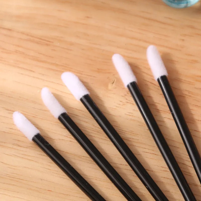 Disposable lip brushes with black handles and flocked tips in bulk packaging for lipstick and gloss application