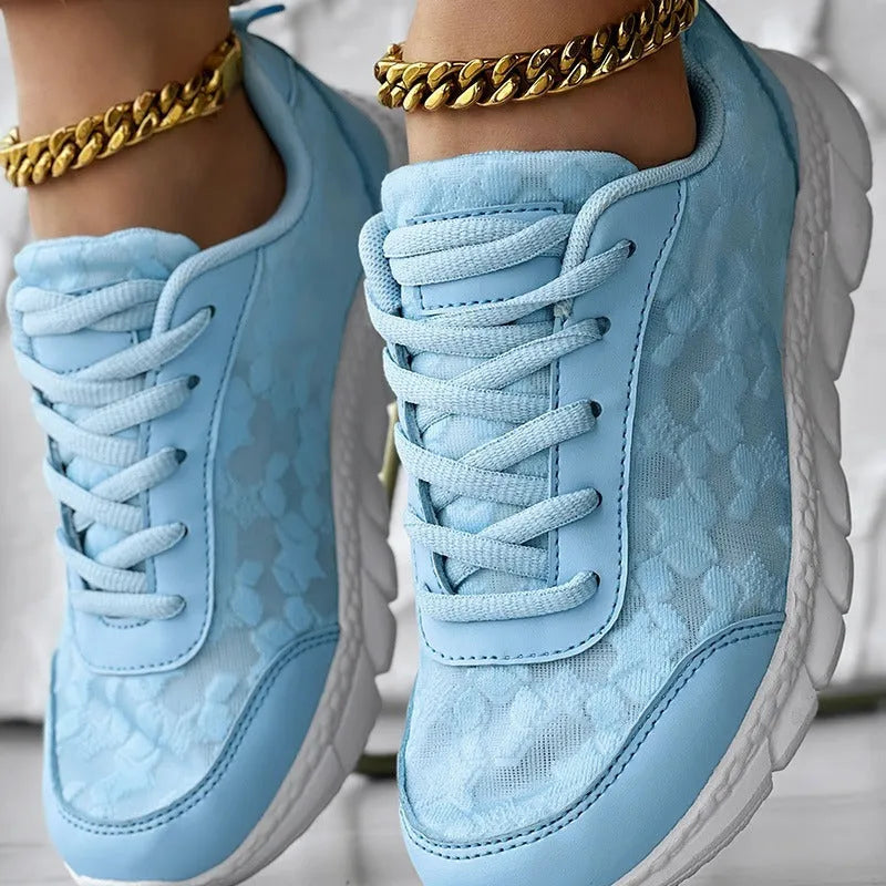 Women's white canvas sports shoes with flat heel and round toe design on neutral background