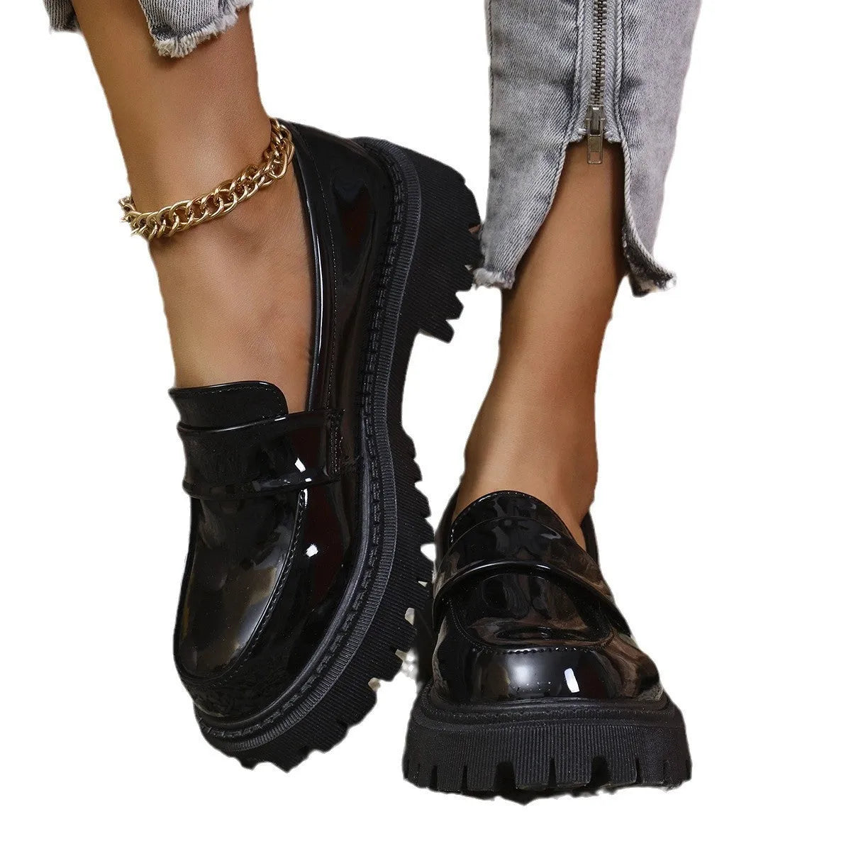 Women's black chunky heel slip-on loafers with a platform sole, shown on a foot.