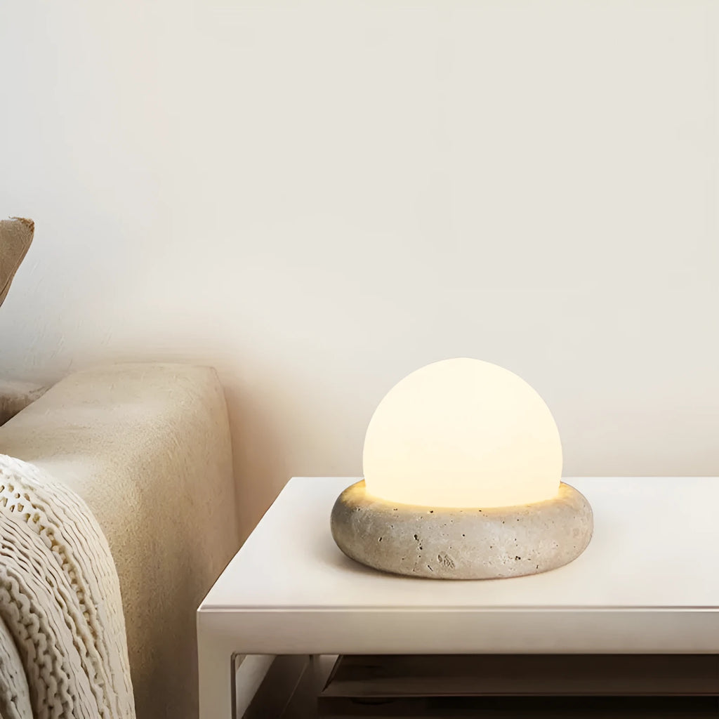 Modern cream-coloured bedside table lamp with wireless remote control on a nightstand.