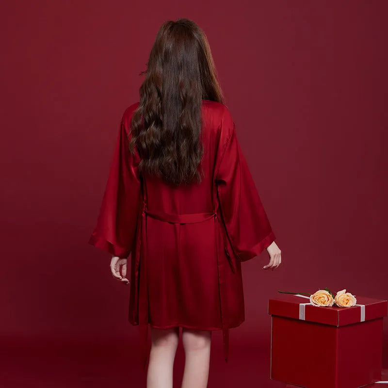 Red men's and women's long sleeve ice silk pyjama set laid flat.