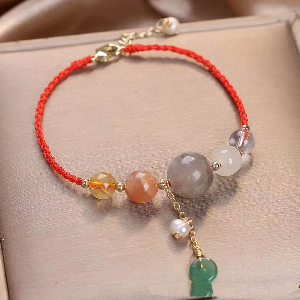 Close-up of a women's adjustable bracelet with crystal and sequin details on a hand-woven peace buckle clasp.