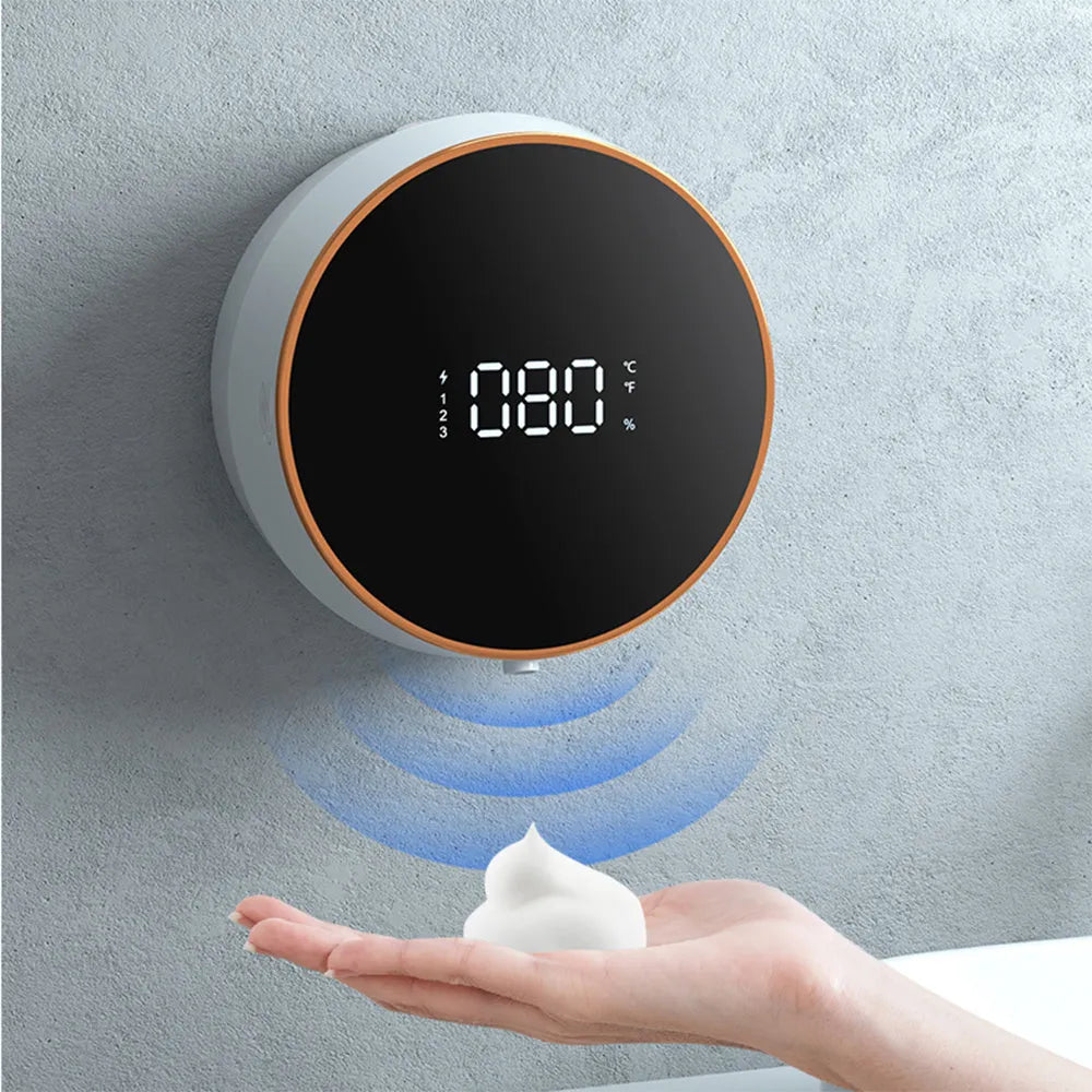 Black automatic sensor foam soap dispenser mounted on a bathroom wall with USB charging cable.