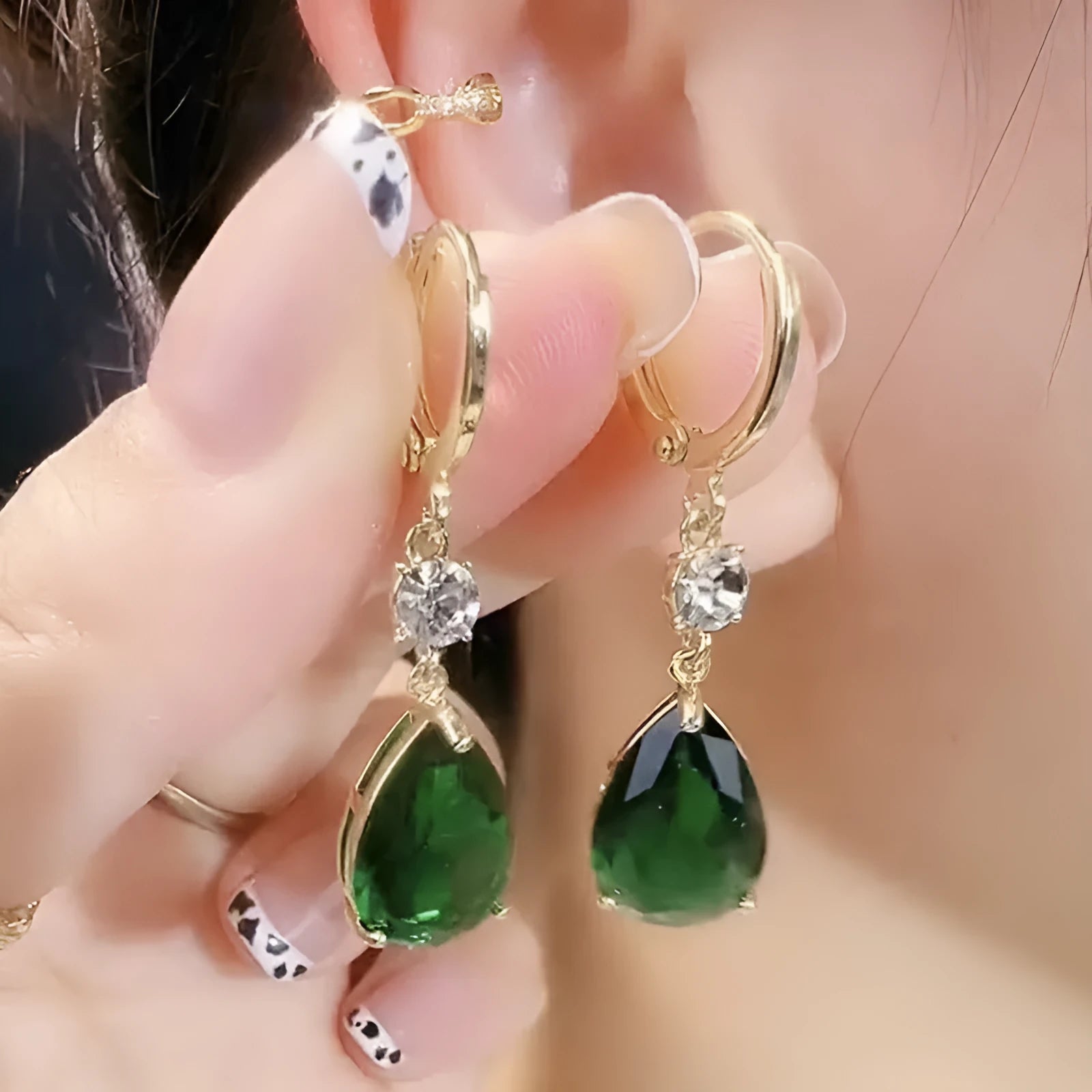A pair of green geometric teardrop alloy earrings on a plain background.