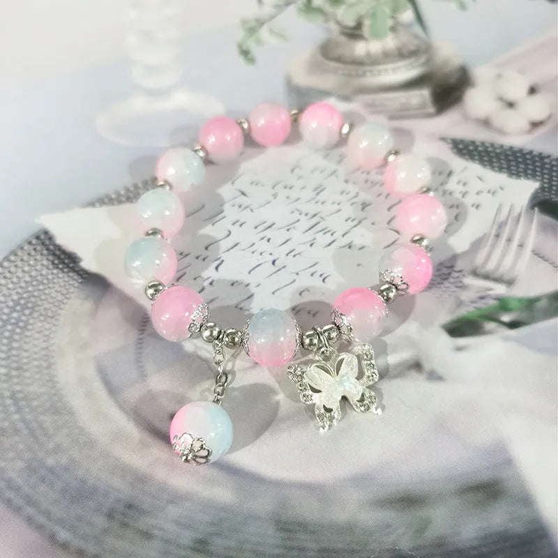A Chinese style glass bracelet with bamboo leaf and bead designs on a wrist.