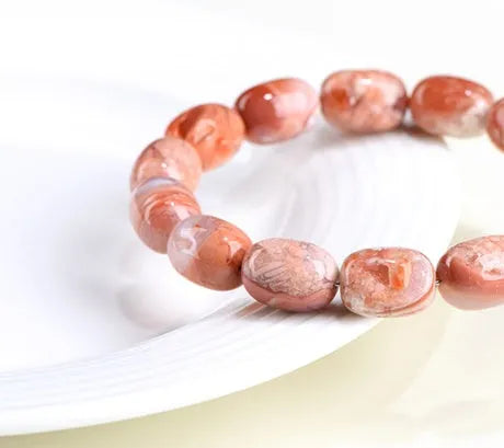 Natural cherry agate barrel bead bracelet with Ruyi design elements on wrist