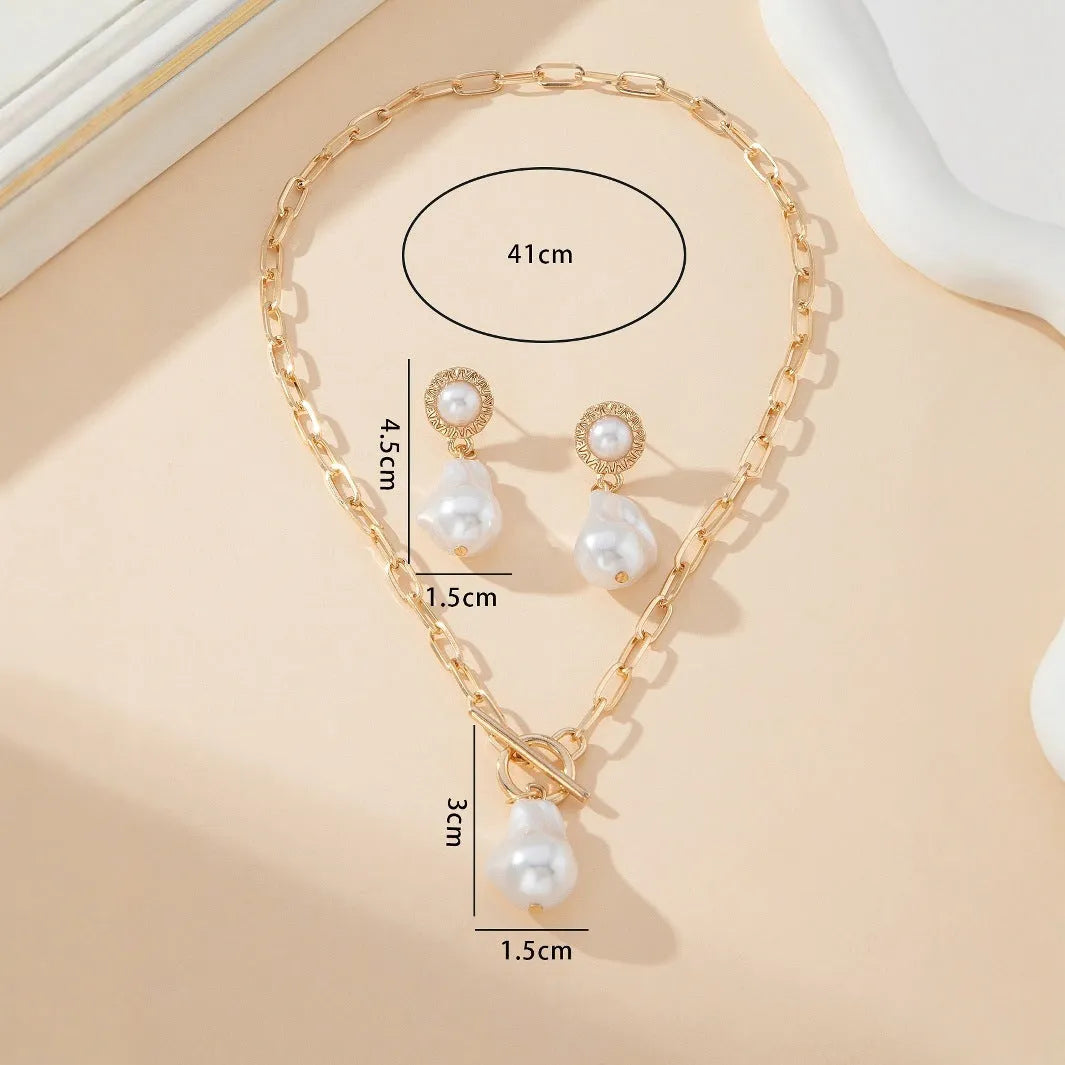 Gold tone retro baroque pearl pendant necklace and matching stud earrings set for women.