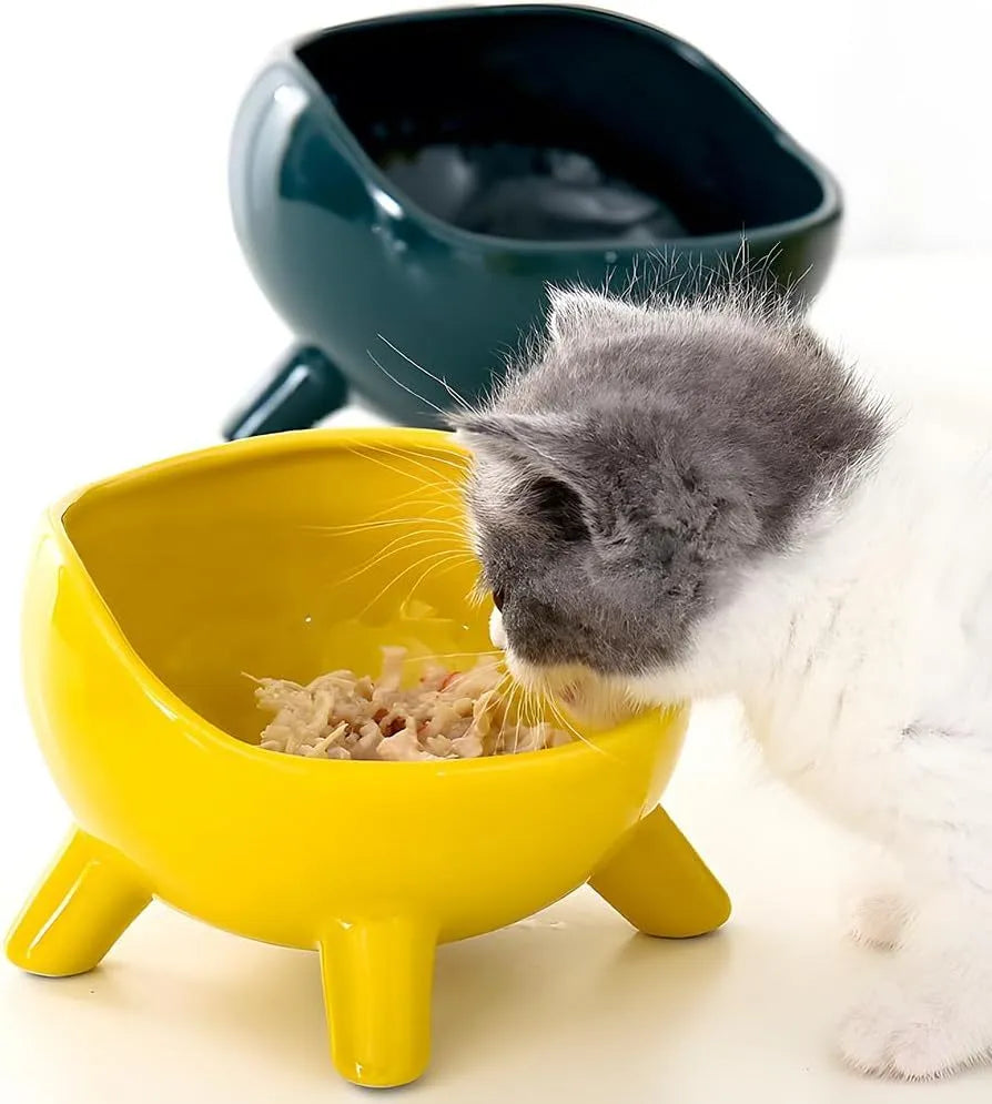 Green ceramic pet food bowl with four legs and a wide, rounded opening.