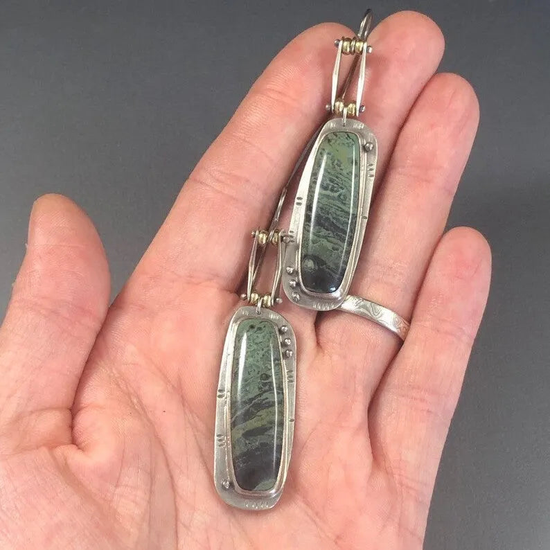Geometric shaped drop earrings with a black and white marble pattern on an alloy metal backdrop.