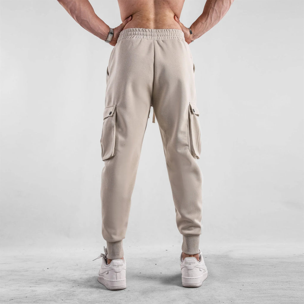 Men's loose ankle-tied cotton sports trousers in multi-pocket design showing apricot colour option