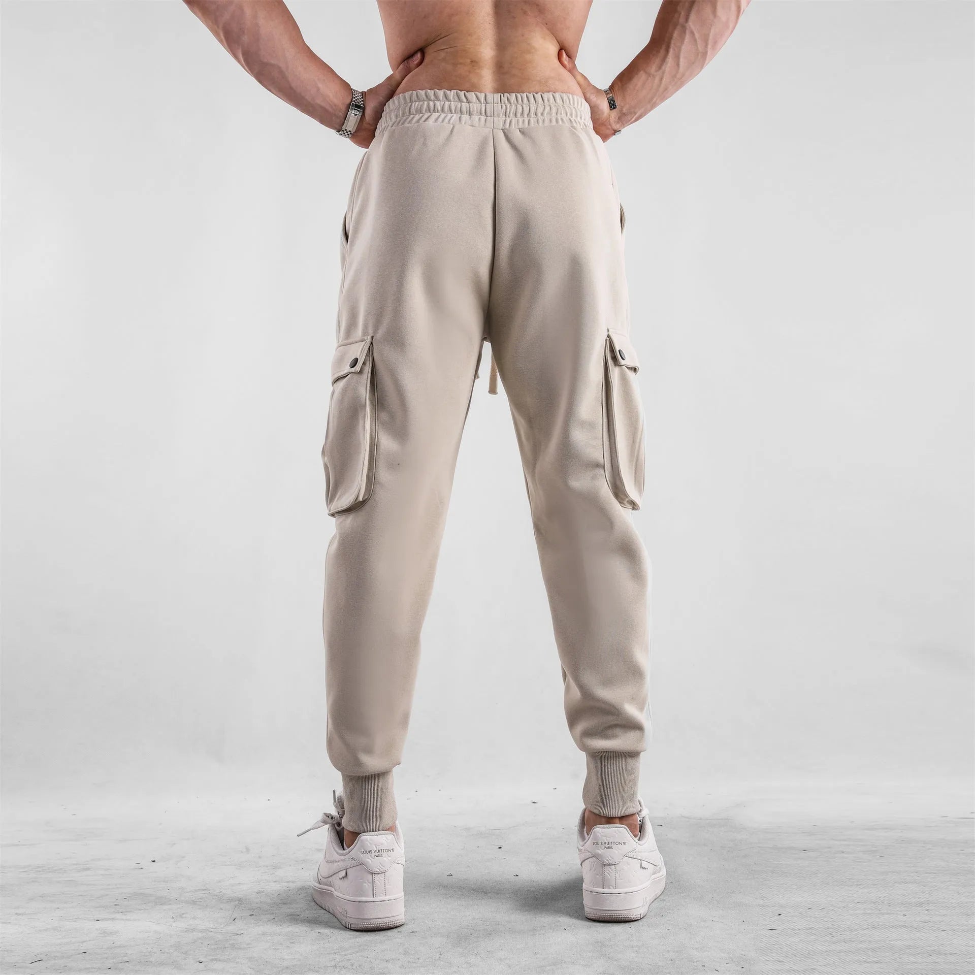 Men's loose ankle-tied cotton sports trousers in multi-pocket design showing apricot colour option