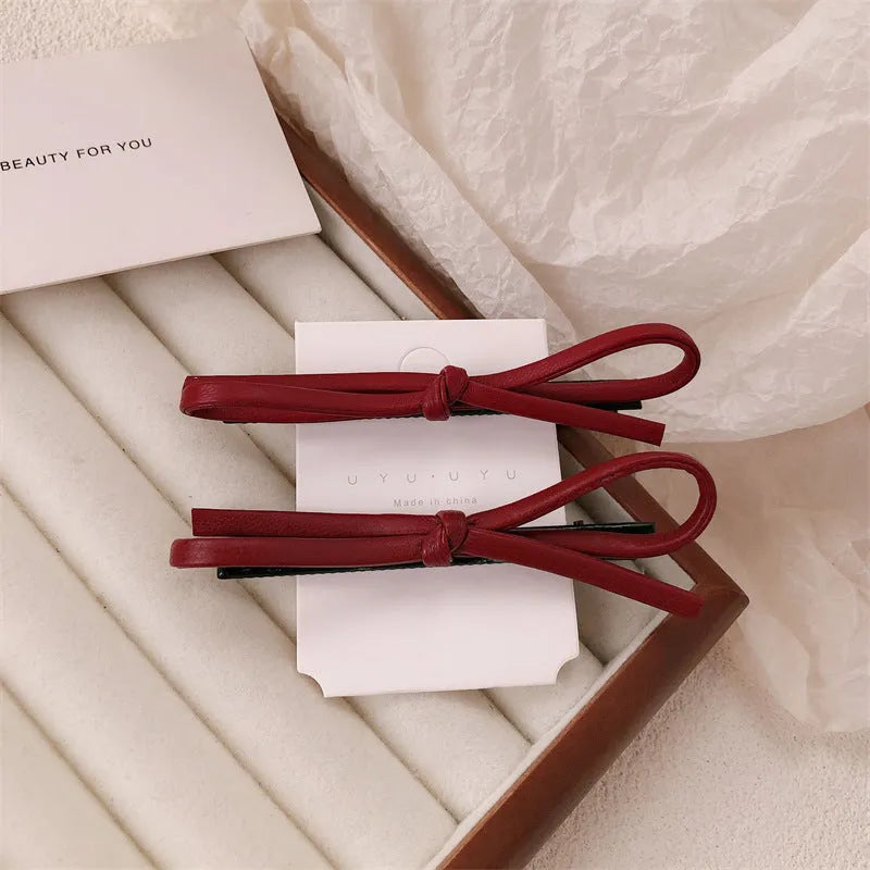 Wine red leather bow hair barrettes showing bow detail and clip mechanism