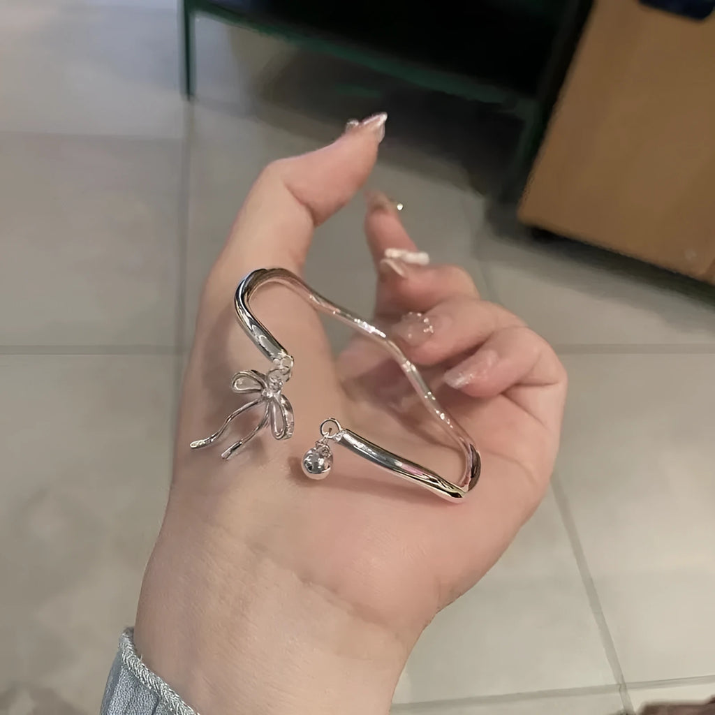 Silver adjustable women's bracelet with bow-shaped bell opening closure on zinc alloy chain