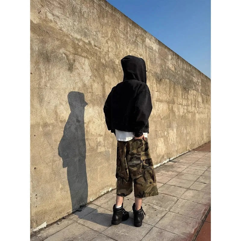 Men's camouflage-colour jeans with patch details, ripped fabric, and a cropped, loose straight-leg fit.