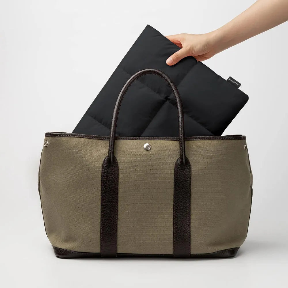 Soft fluffy black polyester laptop sleeve for a 15.6 inch laptop with visible stitching.