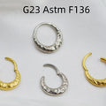 Close-up of a titanium alloy nose ring with concave-convex texture in a gold anodised finish.