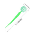 Green TPR bouncy cat toy with a long plush tail on a wooden floor.