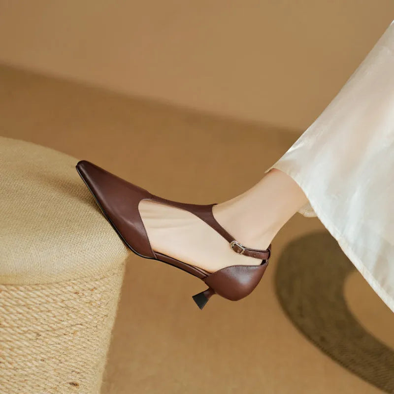 Women's brown and black cowhide high heels with a pointed toe on a white background.
