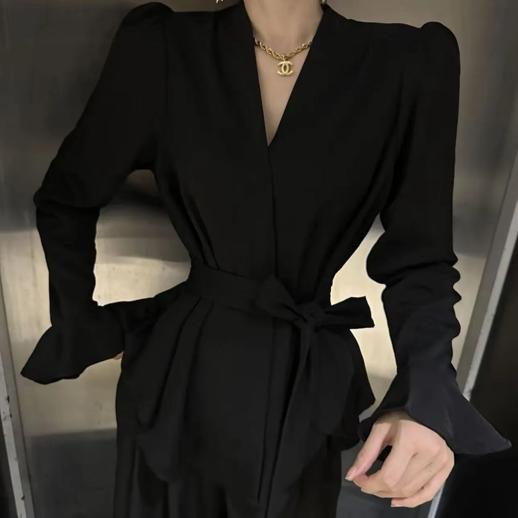 Women's black French-style shirt with irregular collar, tied front, and long bell sleeves.