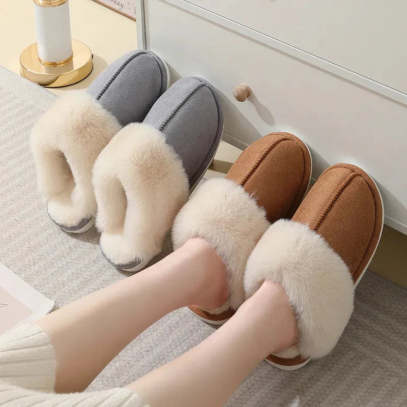 A pair of plush fur-lined indoor slippers with a round toe and a flat PVC sole.