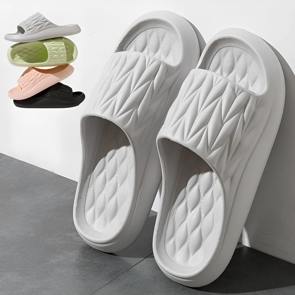Pair of grey EVA foam slippers with leaf texture pattern and non-slip sole.