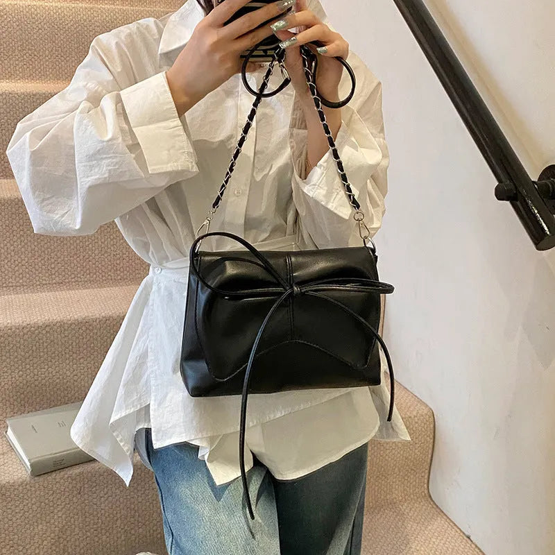 Women's black underarm crossbody bag with horizontal square design and crossbody strap