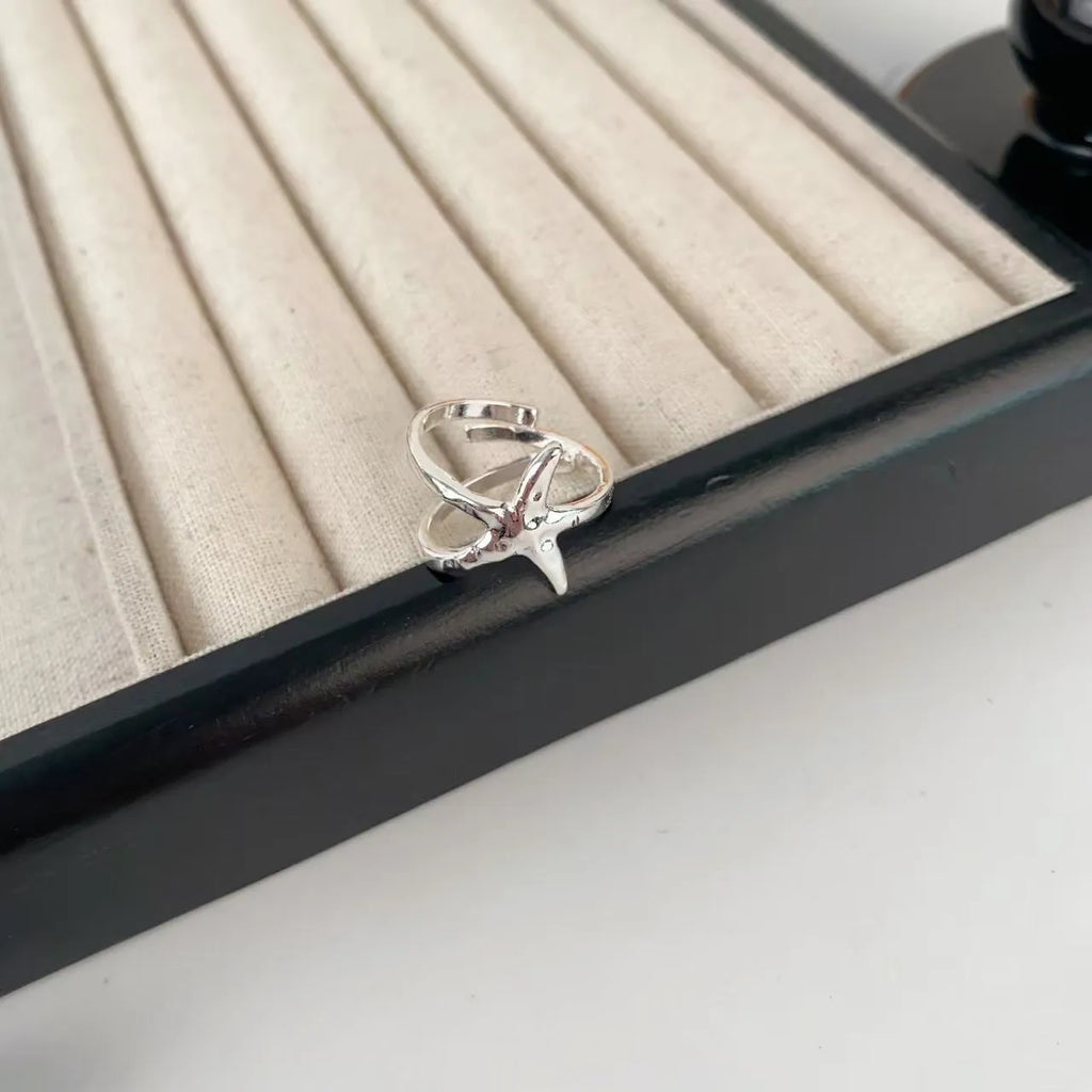 Three-dimensional jasmine flower ring with adjustable open mouth design in zinc alloy.