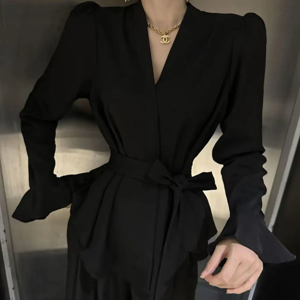 Women's black French-style shirt with irregular collar, tied front, and long bell sleeves.