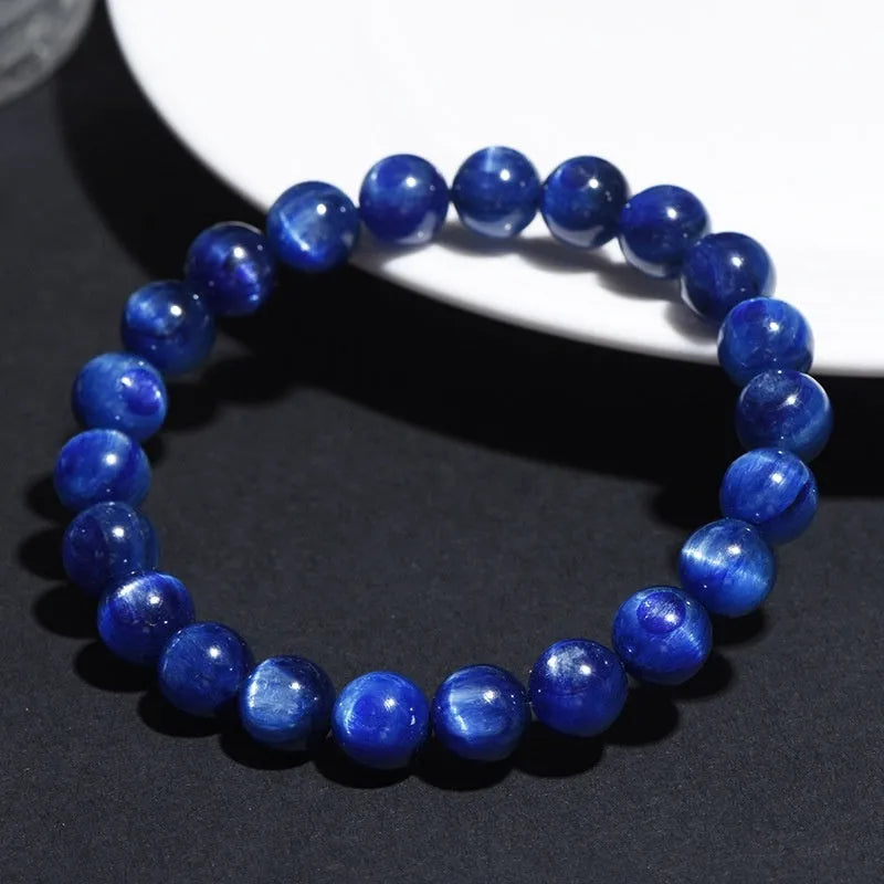 Polished blue crystal ball bracelet with Ruyi charm on a white background.