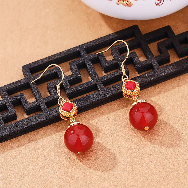Geometric copper alloy earrings with a round Southern Red Agate bead and S925 sterling silver inlay details.