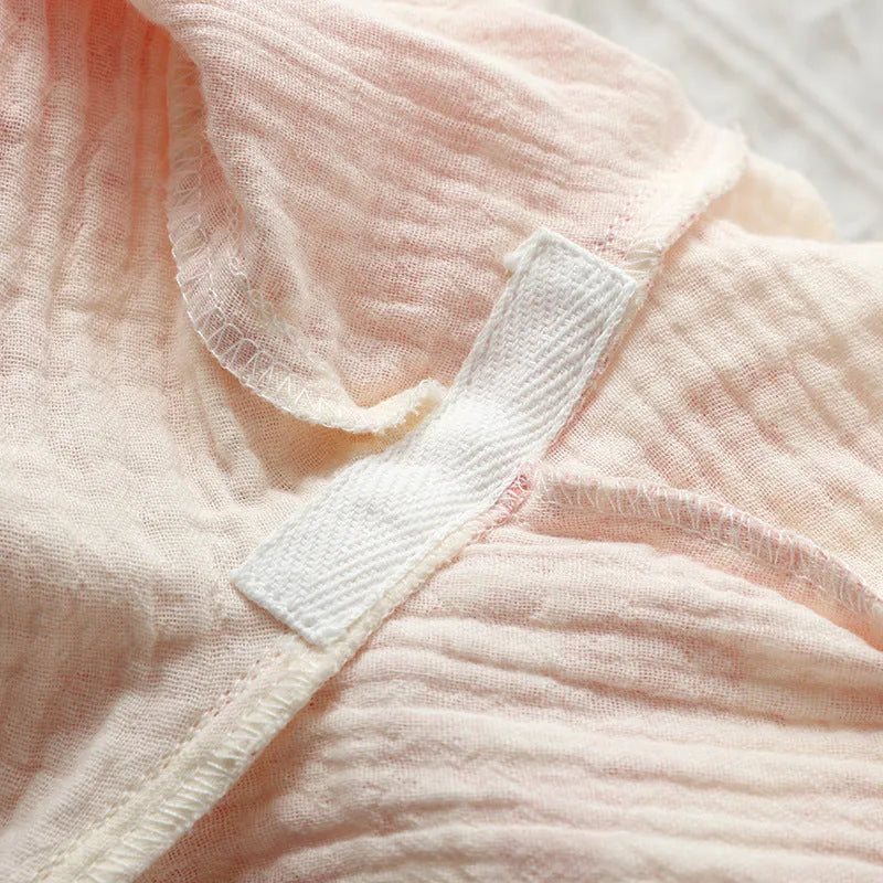 Women's pink cotton gauze lounge suit two-piece set with lace-up front trousers detail.