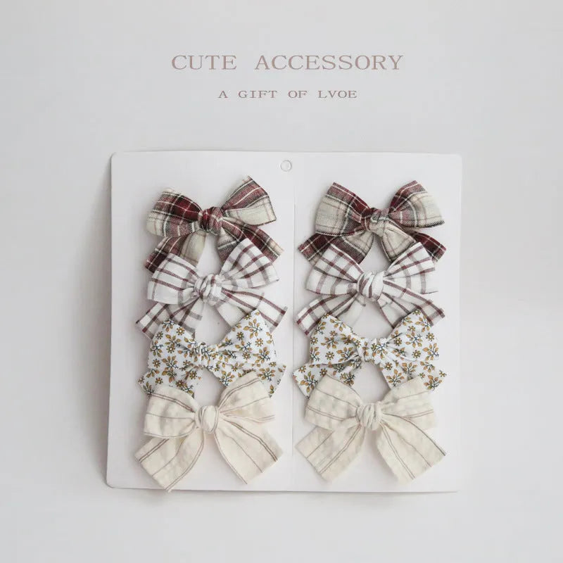 Set of eight fabric dovetail bow hairclips for children in various colours