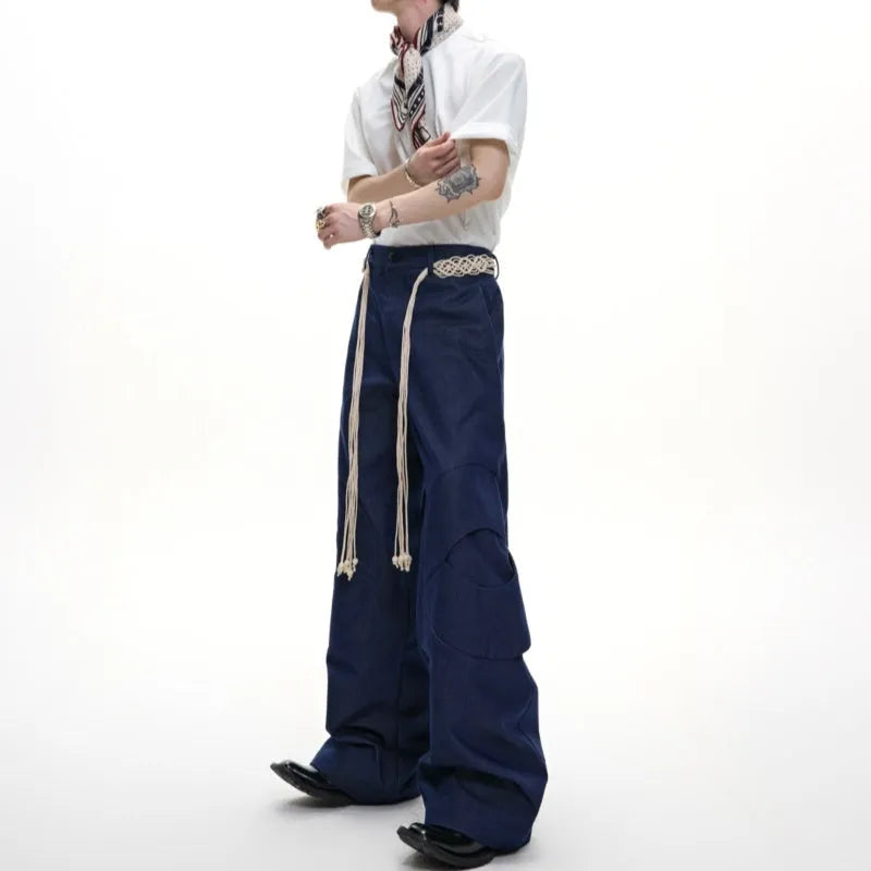 Men's dark blue loose-fit straight-leg cotton trousers with zipper decoration and tassel detail.