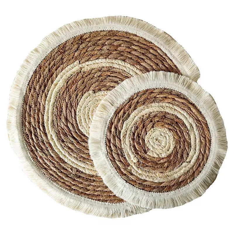 Round papyrus straw placemat with tassel edge in neutral colour on dining table