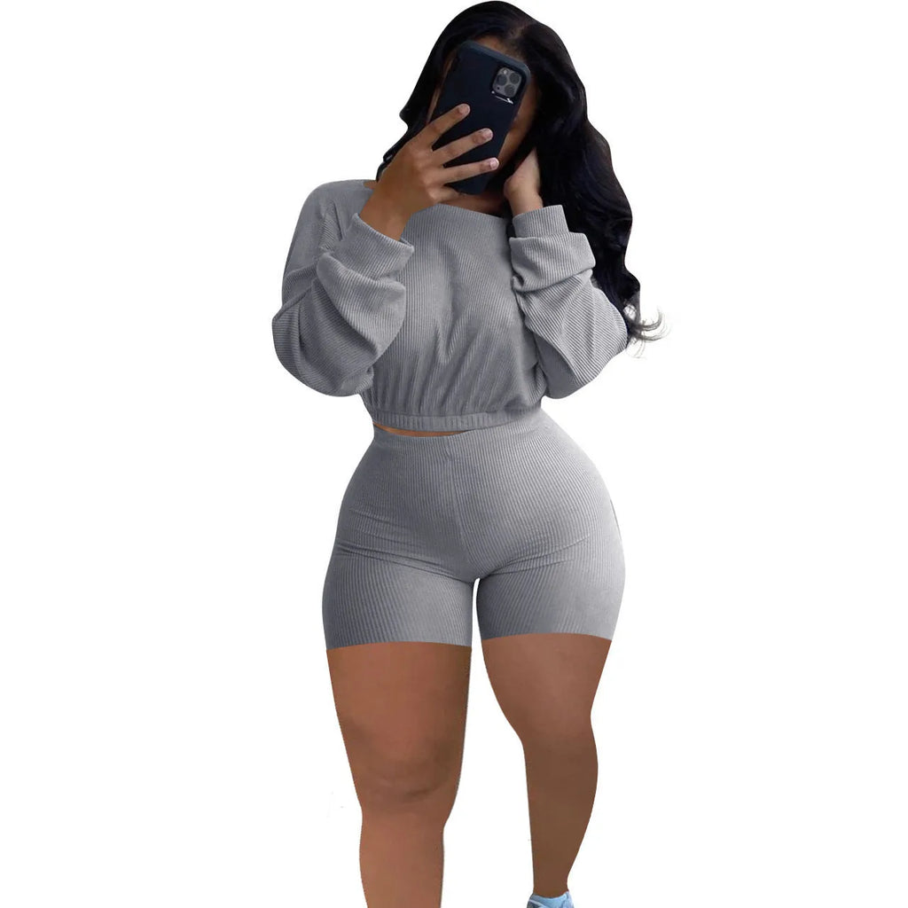 A woman wearing a solid colour off-the-shoulder long-sleeved top and matching shorts from a two-piece set.