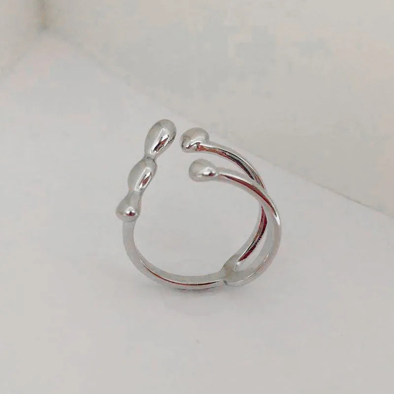 Brass adjustable fashion ring with spherical detail in gold or silver finish.